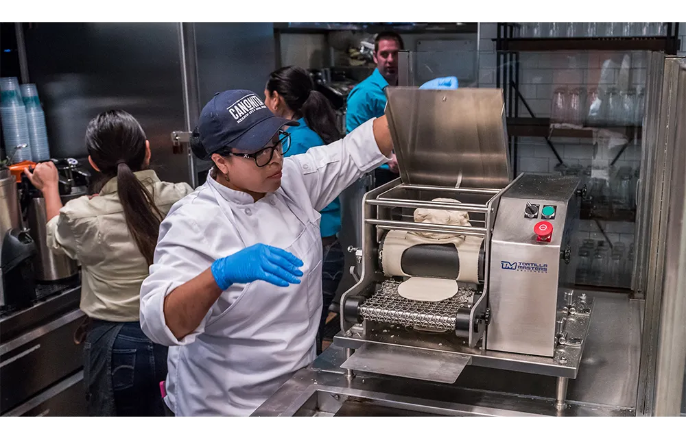 Chef in restaurant kitchen making tortillas